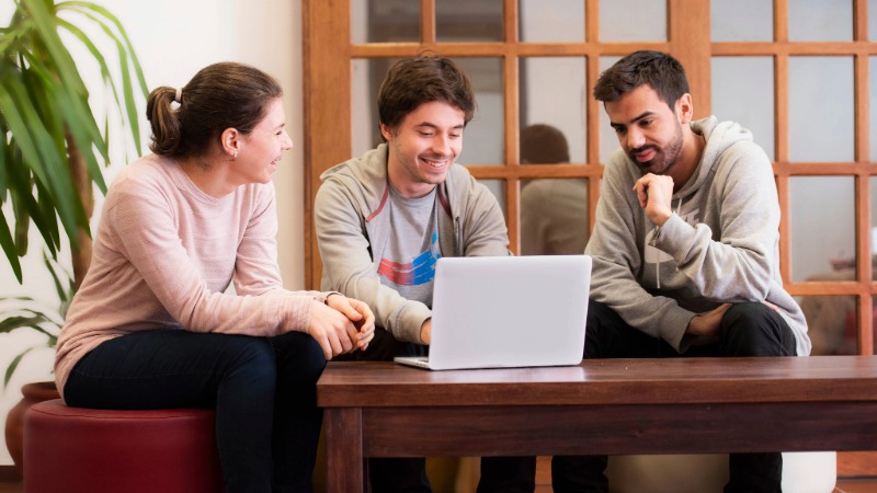 Grupo de estudiantes trabajando en computadora